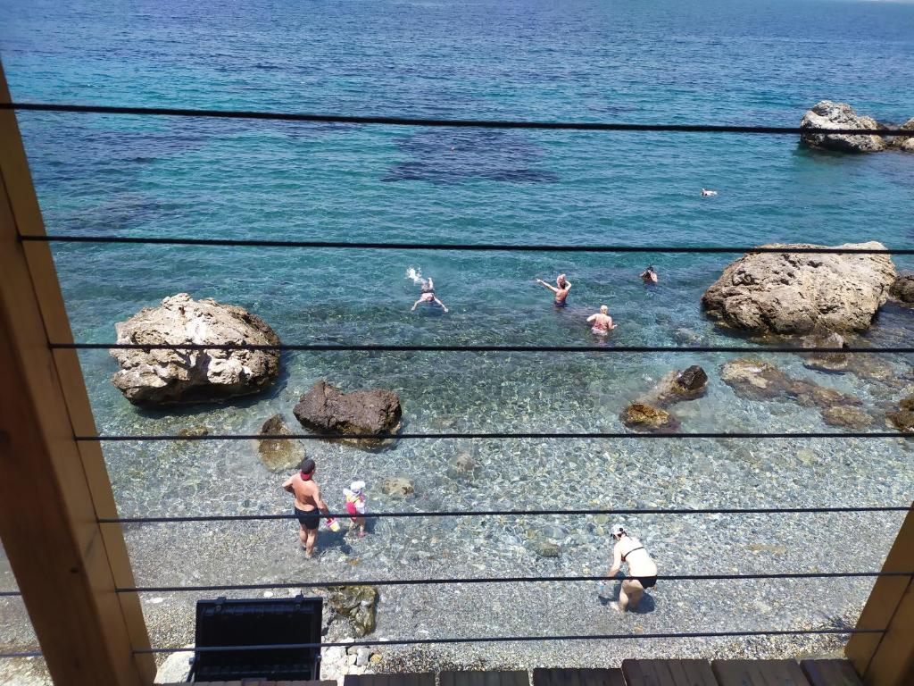 a group of people in the water at the beach at Fatolitis Studios in Masouri