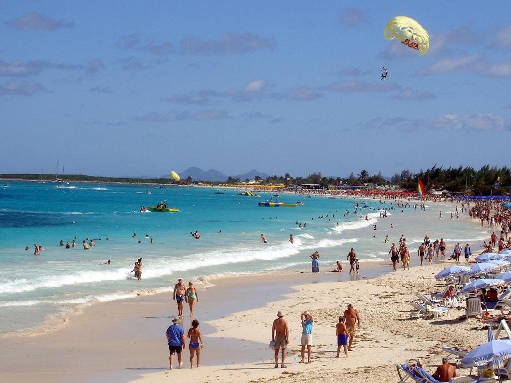 a group of people on a beach with people in the water at Studio Orient Bay in Orient Bay