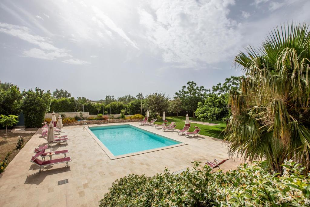 a pool with chaise lounge chairs and a swimming pool at La Vignazza B&B in Marzamemi