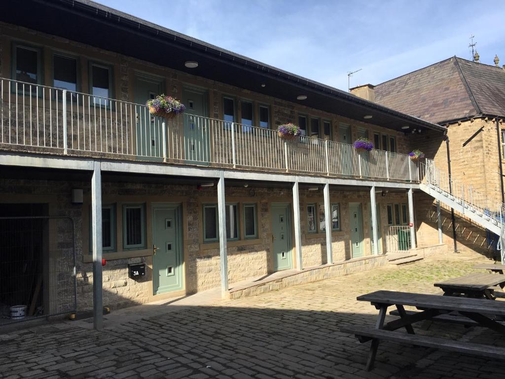 ein Gebäude mit einem Balkon und einem Picknicktisch in der Unterkunft Swans Nest in Holmfirth