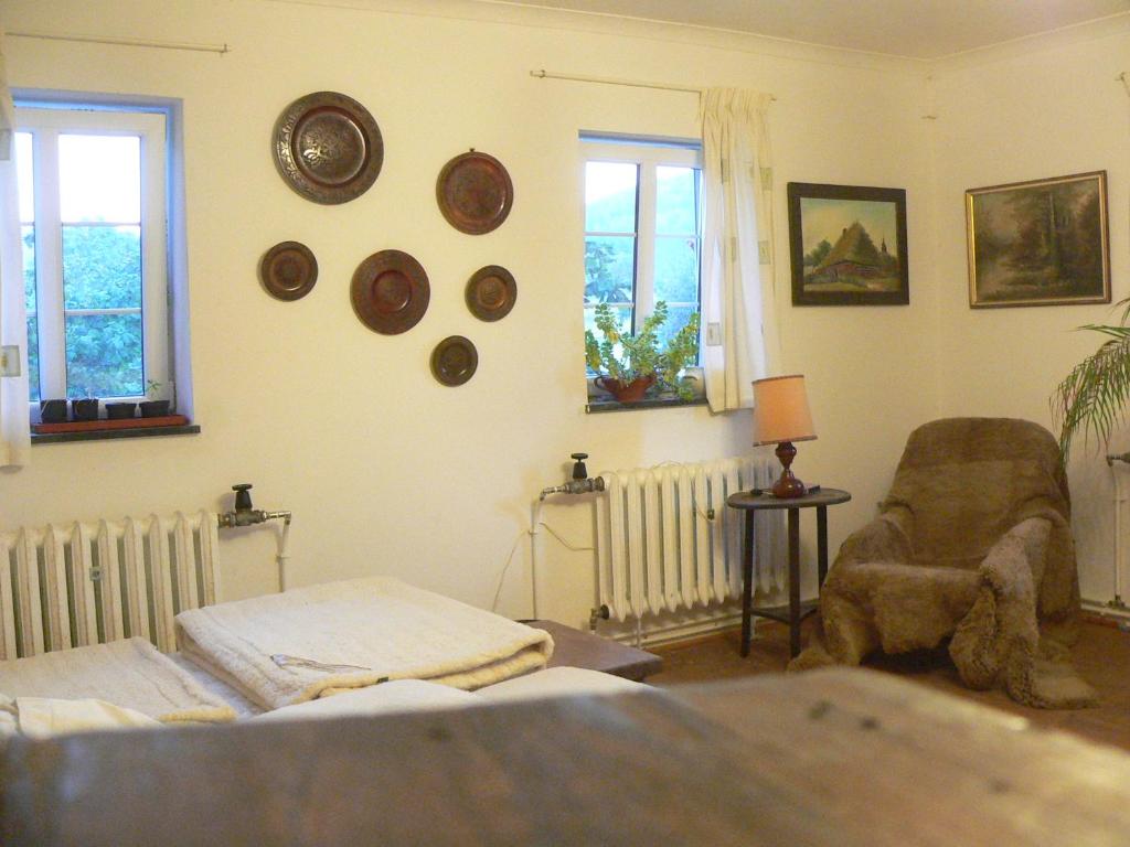 Cette chambre comprend un lit, une chaise et des fenêtres. dans l'établissement STARA PLEBANIA, à Lądek-Zdrój