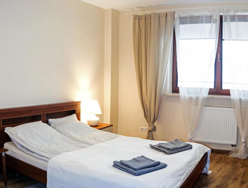 ワルシャワにあるSzucha Apartmentsのベッドルーム1室(ベッド1台、タオル2枚付)