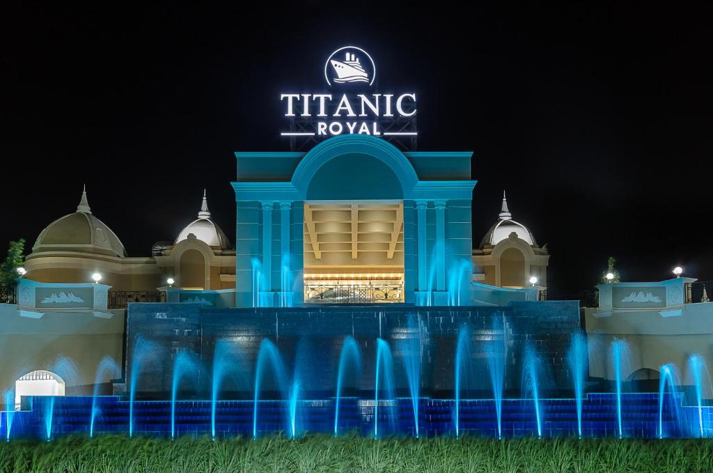 um edifício com um letreiro de néon em frente a uma fonte em Titanic Royal-Families and Couples only em Hurghada