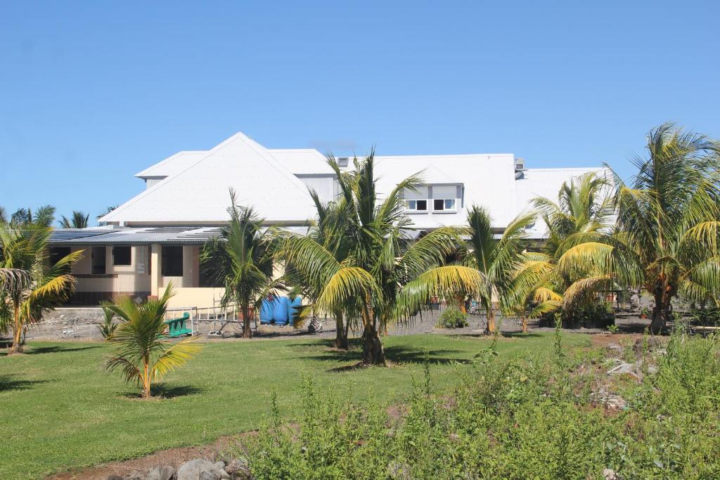 a house with palm trees in front of it at Domaine des Oiseaux Réunion in Saint-André