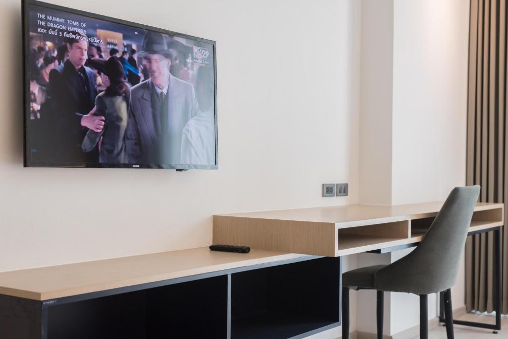 A compact in-room desk with chair, television and storage cabinet.