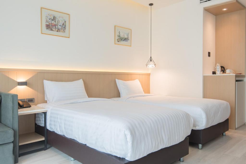 A close view of the twin beds beside the room’s open refreshment cabinet.