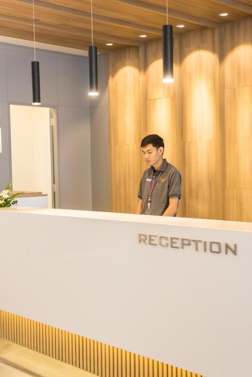 A reception desk with a staff member in a warm wood-paneled lobby.