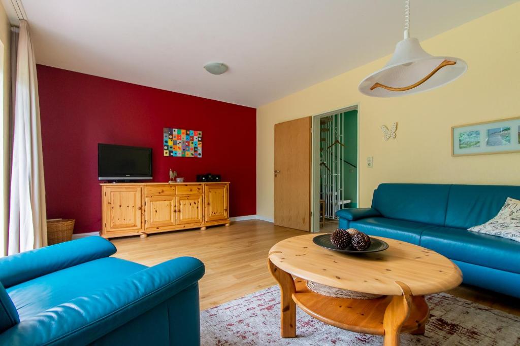 ein Wohnzimmer mit einem blauen Sofa und einem Tisch in der Unterkunft Ferienbauernhof Mau in Fehmarn