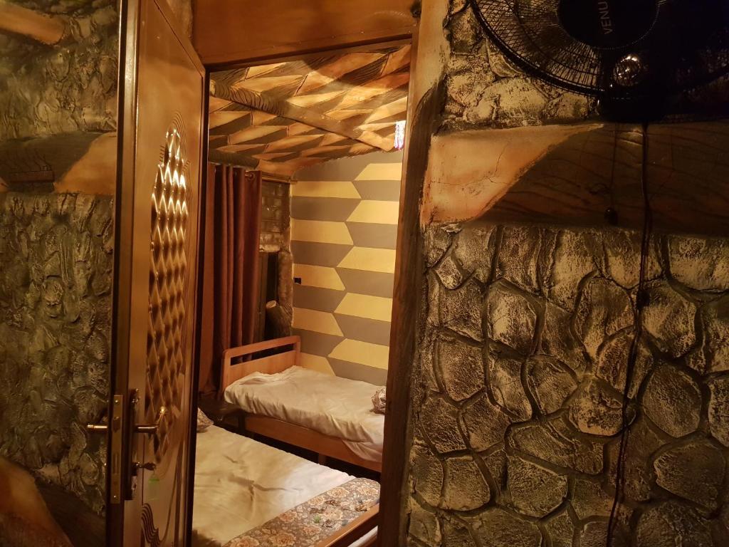 eine offene Tür zu einem Zimmer mit Etagenbett in der Unterkunft Little Petra Heritage Village in Wadi Musa