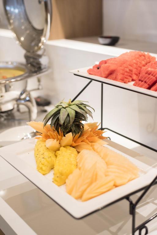 A fruit buffet featuring carved pineapple, melon, watermelon, and papaya.