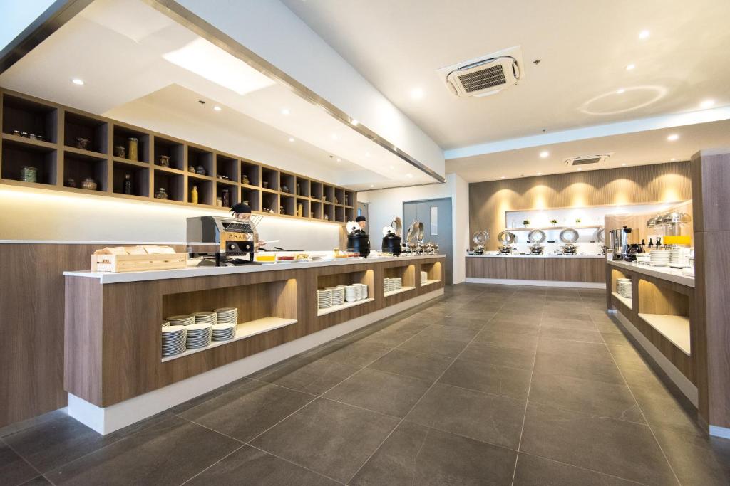 A modern breakfast buffet room with multiple serving counters and a coffee station.