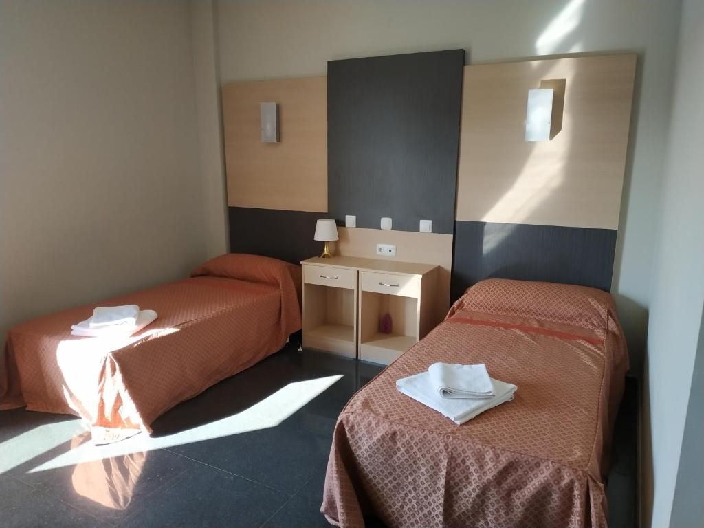 um quarto com duas camas com toalhas em Hostal restaurante la concordia em Fuentes Claras