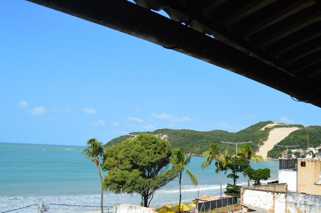 widok na plażę z palmami i ocean w obiekcie Pousada Terra do Sol Natal w mieście Natal