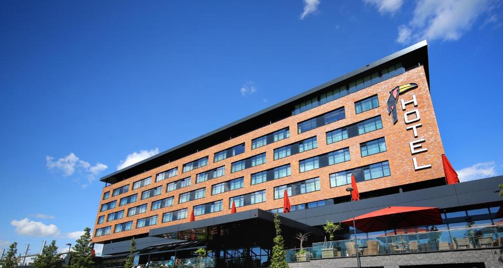 un bâtiment d'hôtel avec un ciel bleu en arrière-plan dans l'établissement Van der Valk Hotel Oostzaan - Amsterdam, à Oostzaan