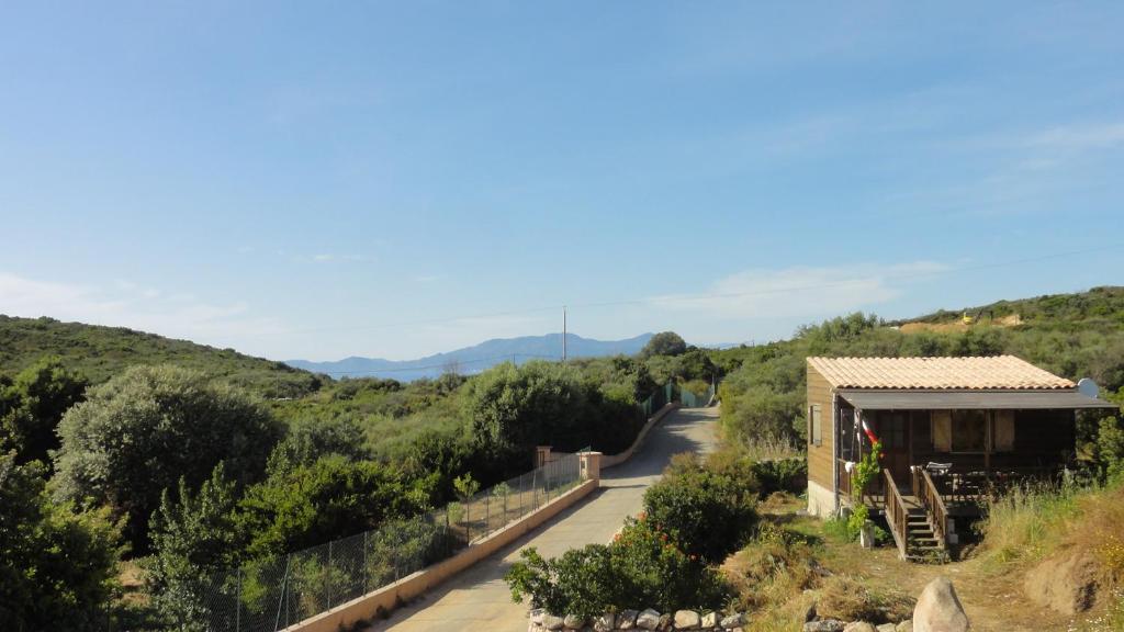 a view of a road with a building and mountains in the background at U Roccu in Coti-Chiavari