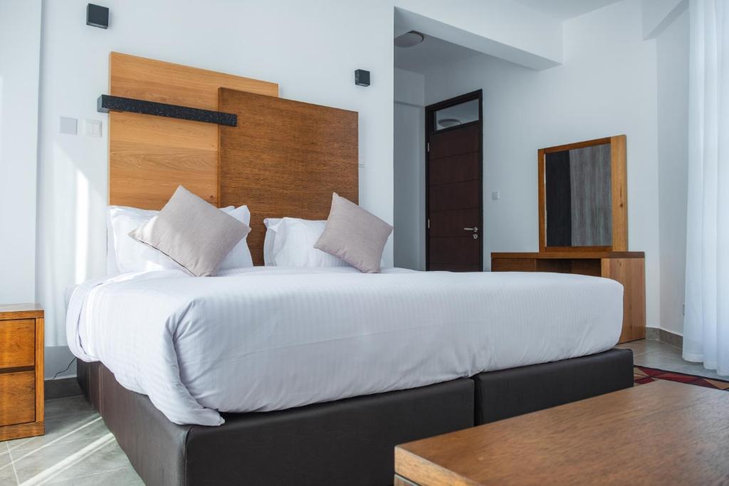 Postel nebo postele na pokoji v ubytování L'Aziz Suites