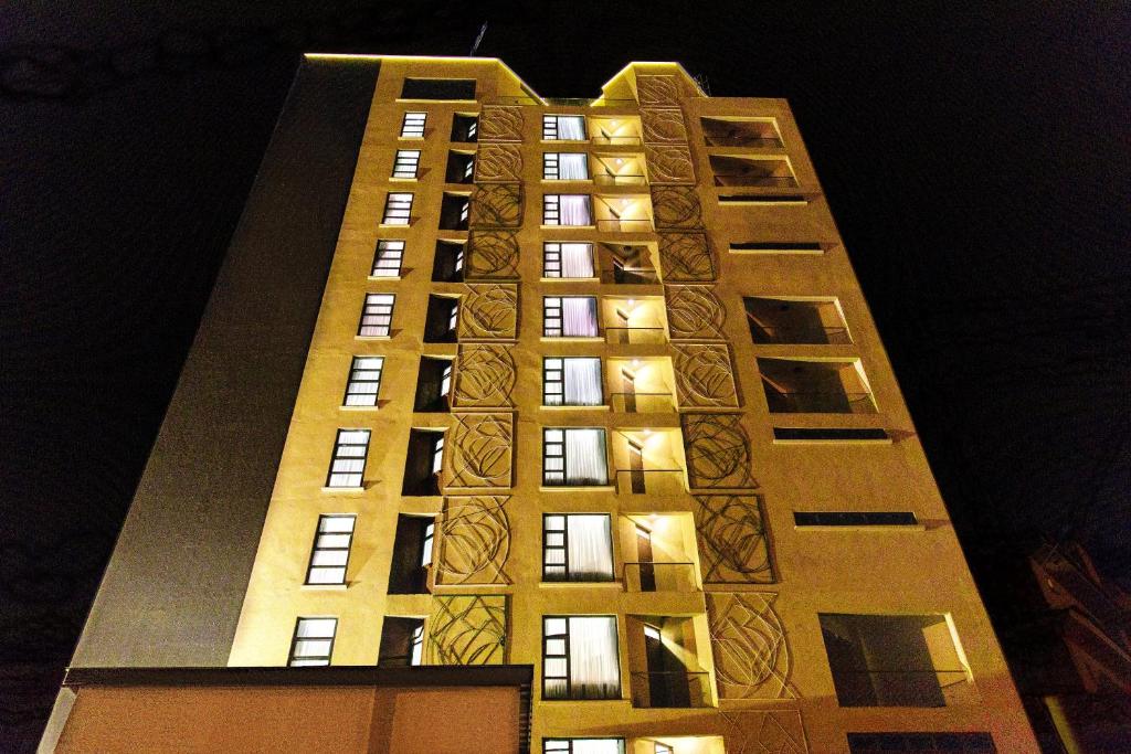 a tall building at night with lights on it at L'Aziz Suites in Nairobi