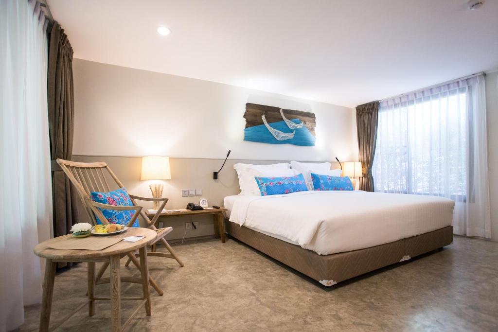 a bedroom with a bed and a table and a chair at Deevana Krabi Resort in Ao Nang Beach