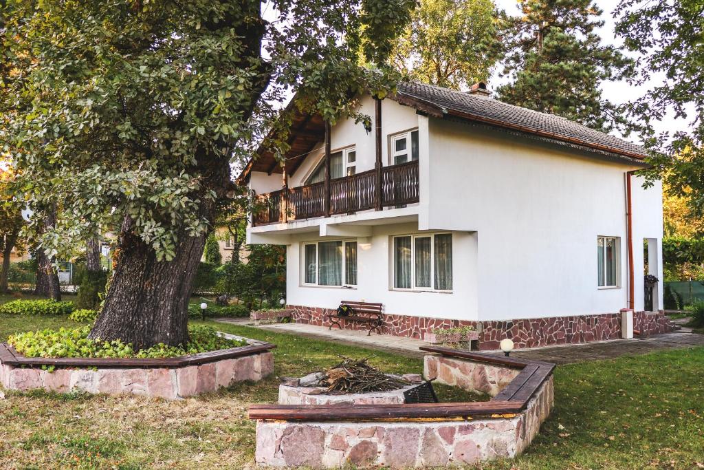 een wit huis met een boom ervoor bij Nature Guesthouse in Varshets