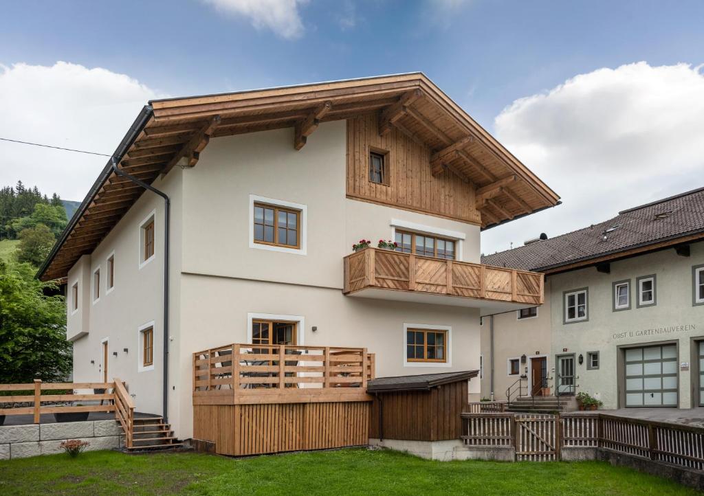 een groot wit huis met een houten dak bij Haus Klingenschmid in Hopfgarten im Brixental