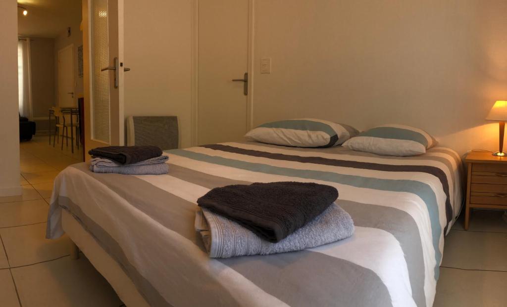 - 2 lits dans une chambre avec des serviettes dans l'établissement Brive Centre, à Brive-la-Gaillarde