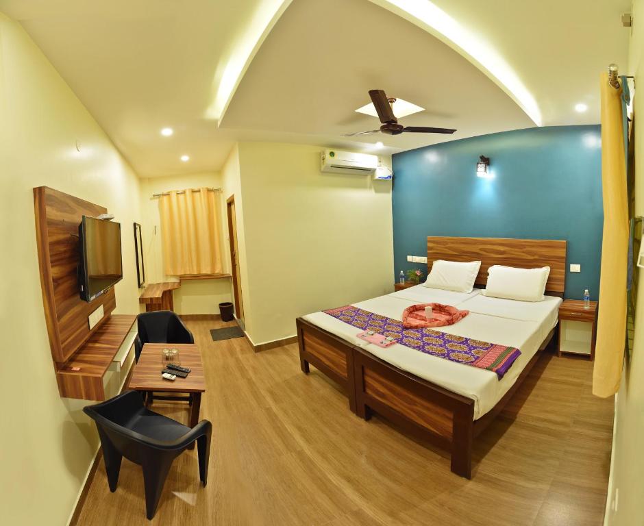 a bedroom with a bed and a tv in it at Siva Residency in Mahabalipuram