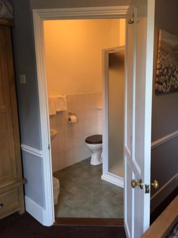 a bathroom with a toilet and a door open at The Old Alma Inn Ltd in Chilham