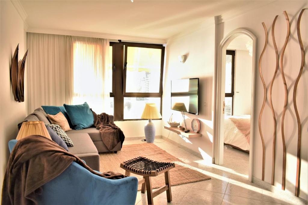 uma sala de estar com um sofá e uma cama em Horizont Patalavaca Beach Mogán & Parking em Patalavaca