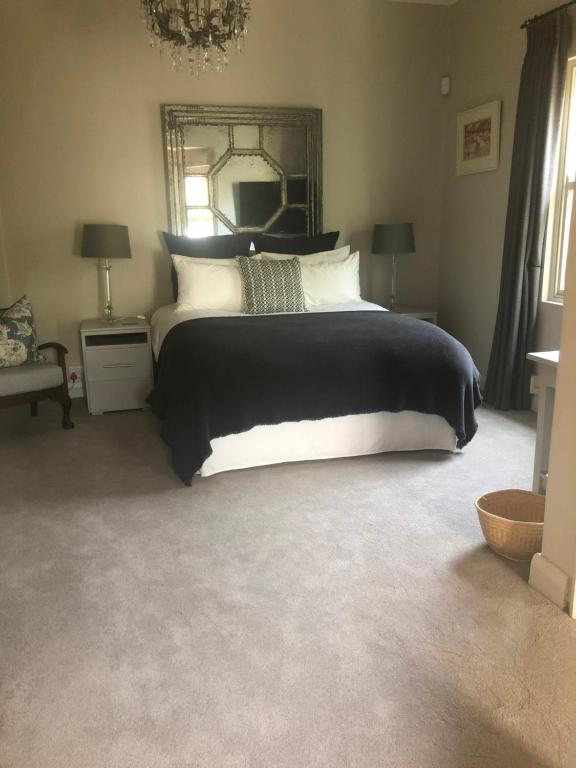 1 dormitorio con 1 cama grande y espejo en Elton, en Ciudad del Cabo