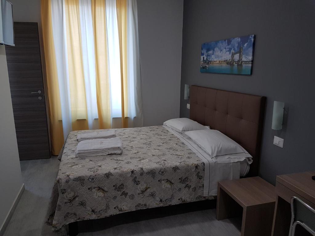 sypialnia z łóżkiem i oknem w obiekcie Hotel Oregon w Mediolanie