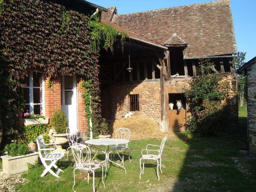 - une table et des chaises dans la cour d'une maison dans l'établissement LA PROVIDENCE, à Le Noyer