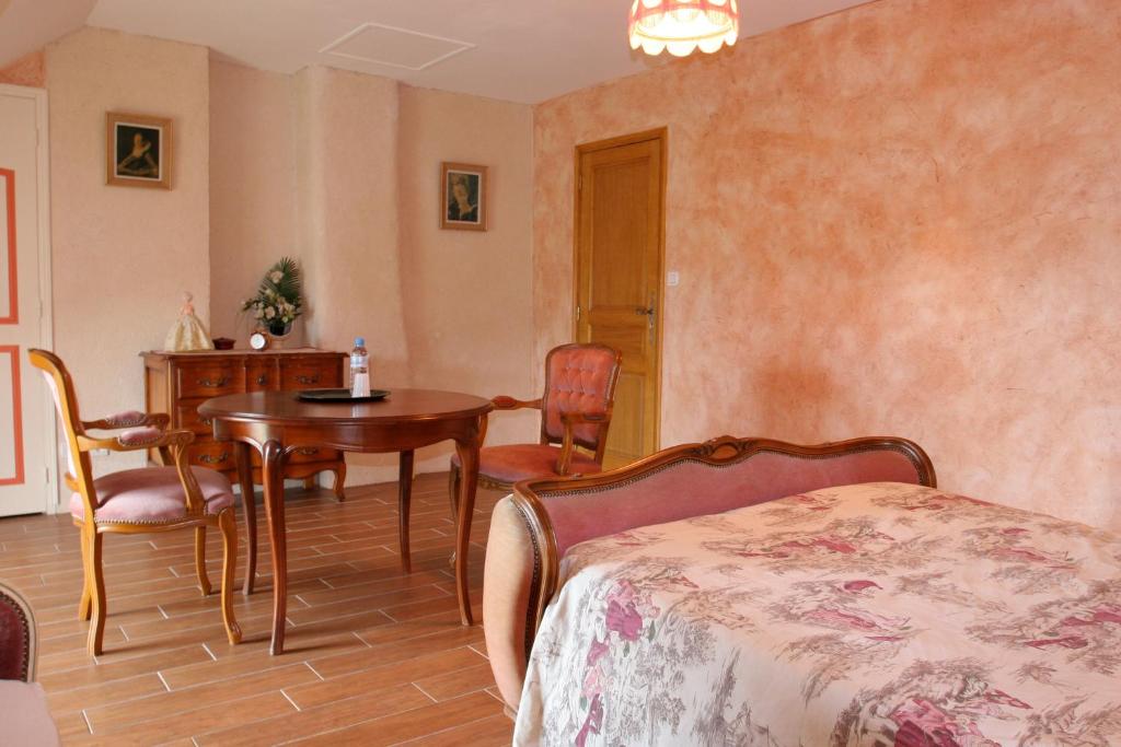 a bedroom with a table and a table and chairs at Chambres d'hôtes de Lunel in Tresboeuf
