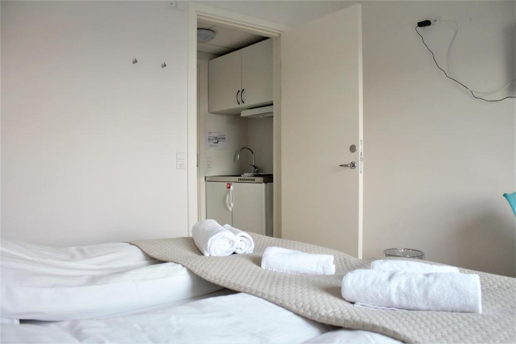 a room with a bed with towels on it at Hotel Nuka in Ilulissat