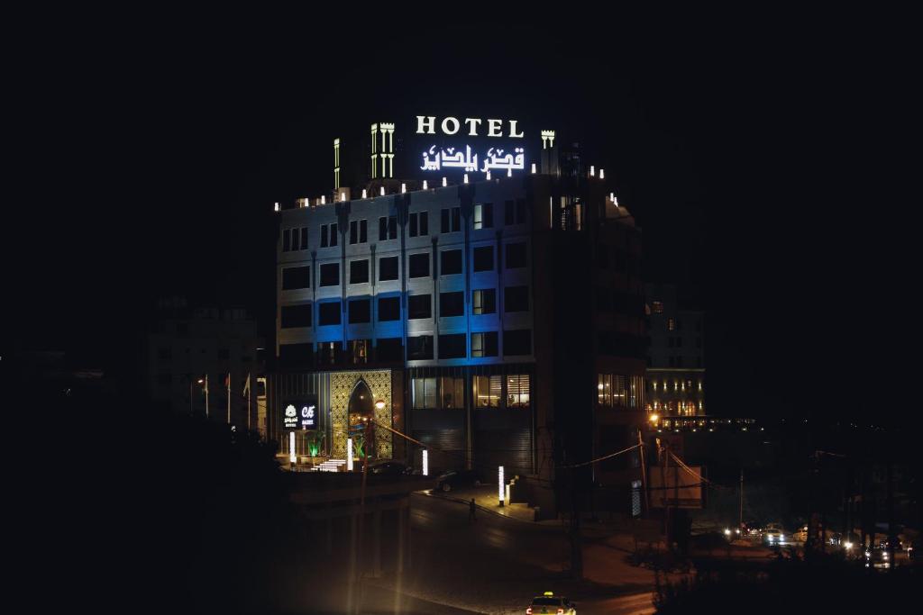 un hotel con un cartel encima de él por la noche en Yaldiz Palace Hotel en Nablus