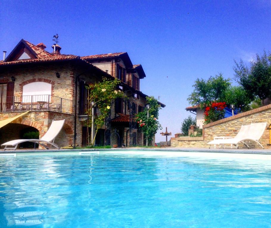 a large swimming pool in front of a house at Agriturismo Il Bricco in Treiso