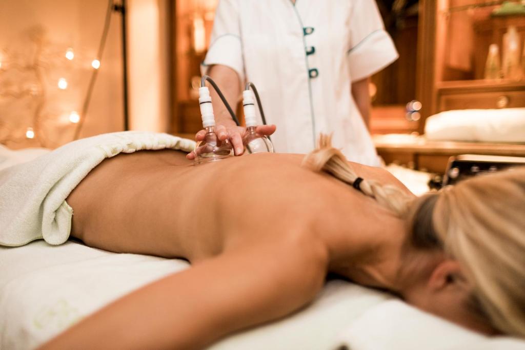 a woman in a spa salon getting her backlished at Hotel Genziana in Selva di Val Gardena
