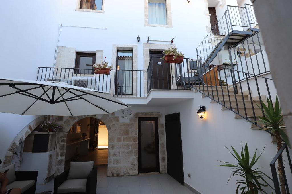 - un couloir d'une maison avec des escaliers et un parasol dans l'établissement Italiana Resort Atrio, à Syracuse