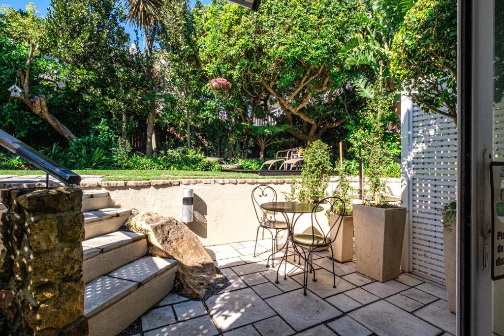 a patio with a table and chairs next to a pool at 3 On Camps Bay in Cape Town