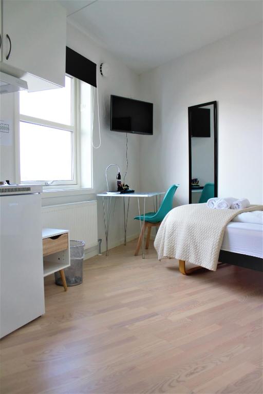 a bedroom with a bed and a table and a desk at Hotel Nuka in Ilulissat