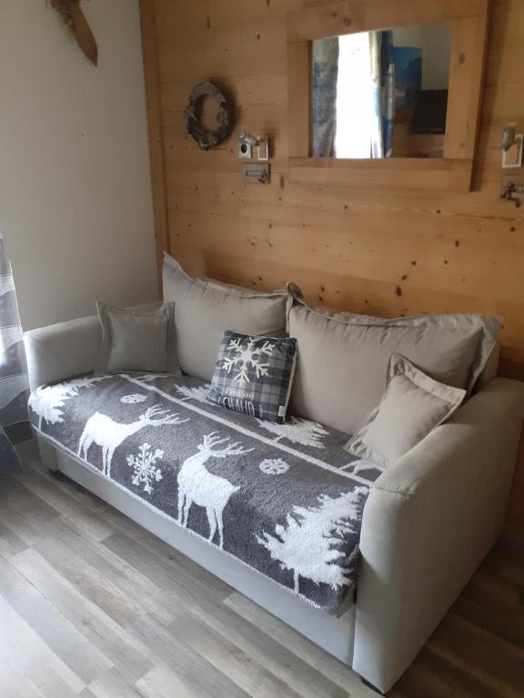 a couch with a blanket on it in a room at Appartement Les Glieres in Bourg-Saint-Maurice