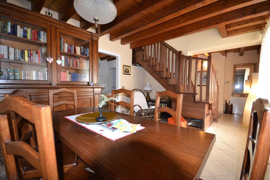 a dining room with a wooden table and bookshelves at Attico in centro storico con wifi e posto auto privato - CIR VDA AOSTA 0267 in Aosta
