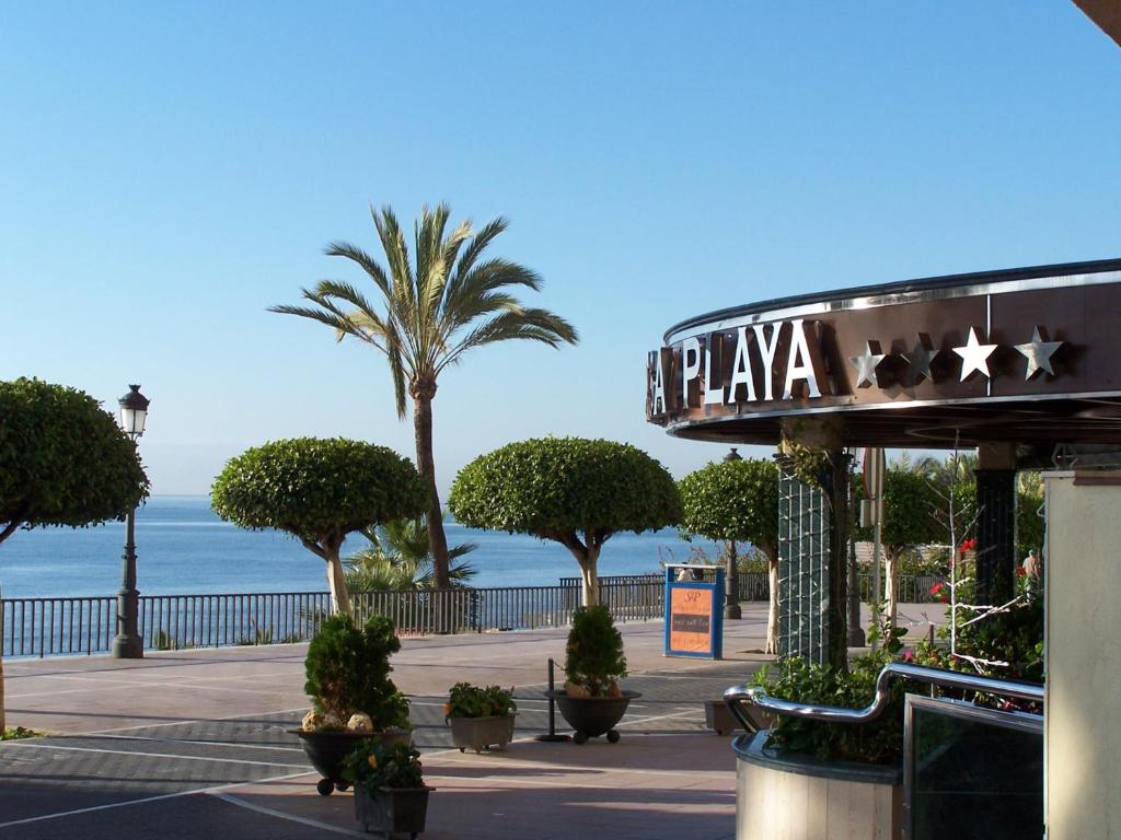 a sign for a plaza with palm trees and the ocean at Ona Princesa Playa in Marbella