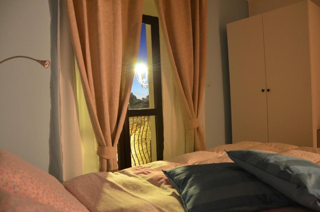 a bedroom with a bed and a window with curtains at Eco del ponte in Sasso di Castalda
