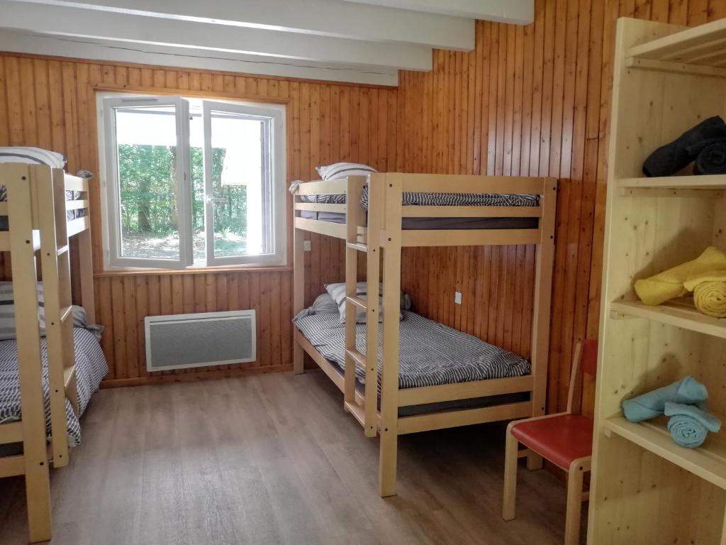 a room with bunk beds and a window at La Truite in Saint-Amans-Valtoret