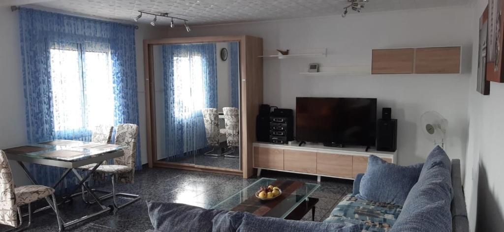 sala de estar con sofá azul y TV en Apartment Alicante, en Alicante