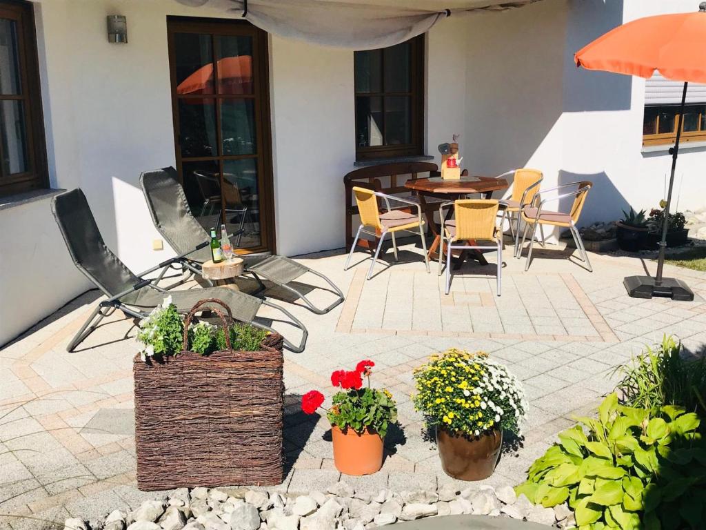 eine Terrasse mit einem Tisch, Stühlen und Pflanzen in der Unterkunft Zollern-Alb Aktiv in Albstadt