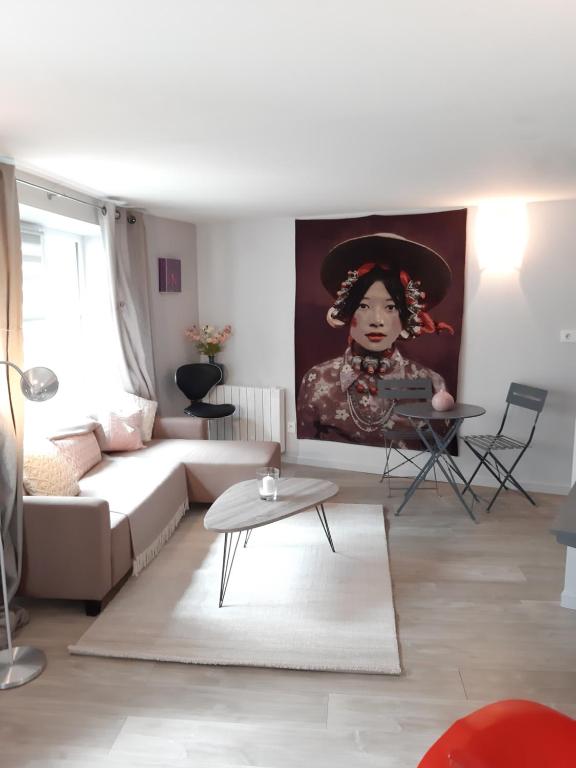 - un salon avec un canapé et une peinture de femme dans l'établissement Souplex de la rue froide, à Caen