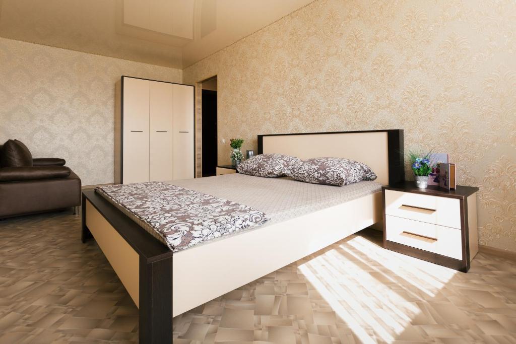 1 dormitorio con 1 cama grande y 1 silla en Luxury apart-hotel on Kharkovskaya neer Manufaktura en Sumy