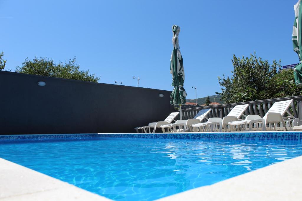 una piscina con sillas y una piscina en Apartments Aldi, en Mostar