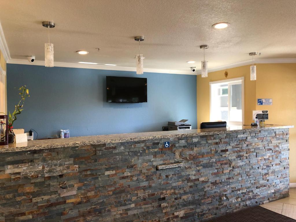 um bar com uma televisão numa parede azul em Lake Point Lodge em Clearlake Oaks